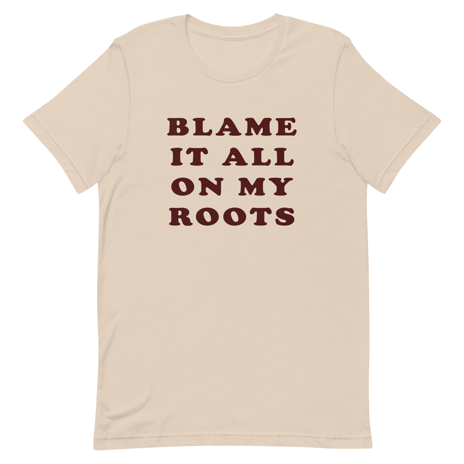 Beige t-shirt, front view, with a caption of blame it all on my roots. This is a lyric from the Garth Brooks song, friends in low places.